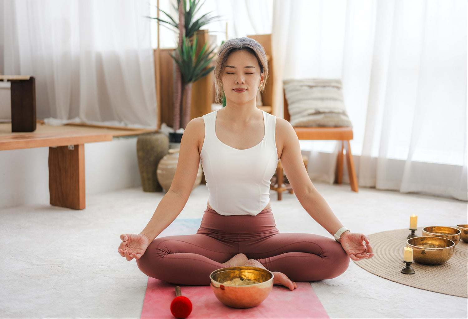 Woman meditating indoors with a Serene Streams Tibetan singing bowl, drawing forward natural harmony and deep calm
