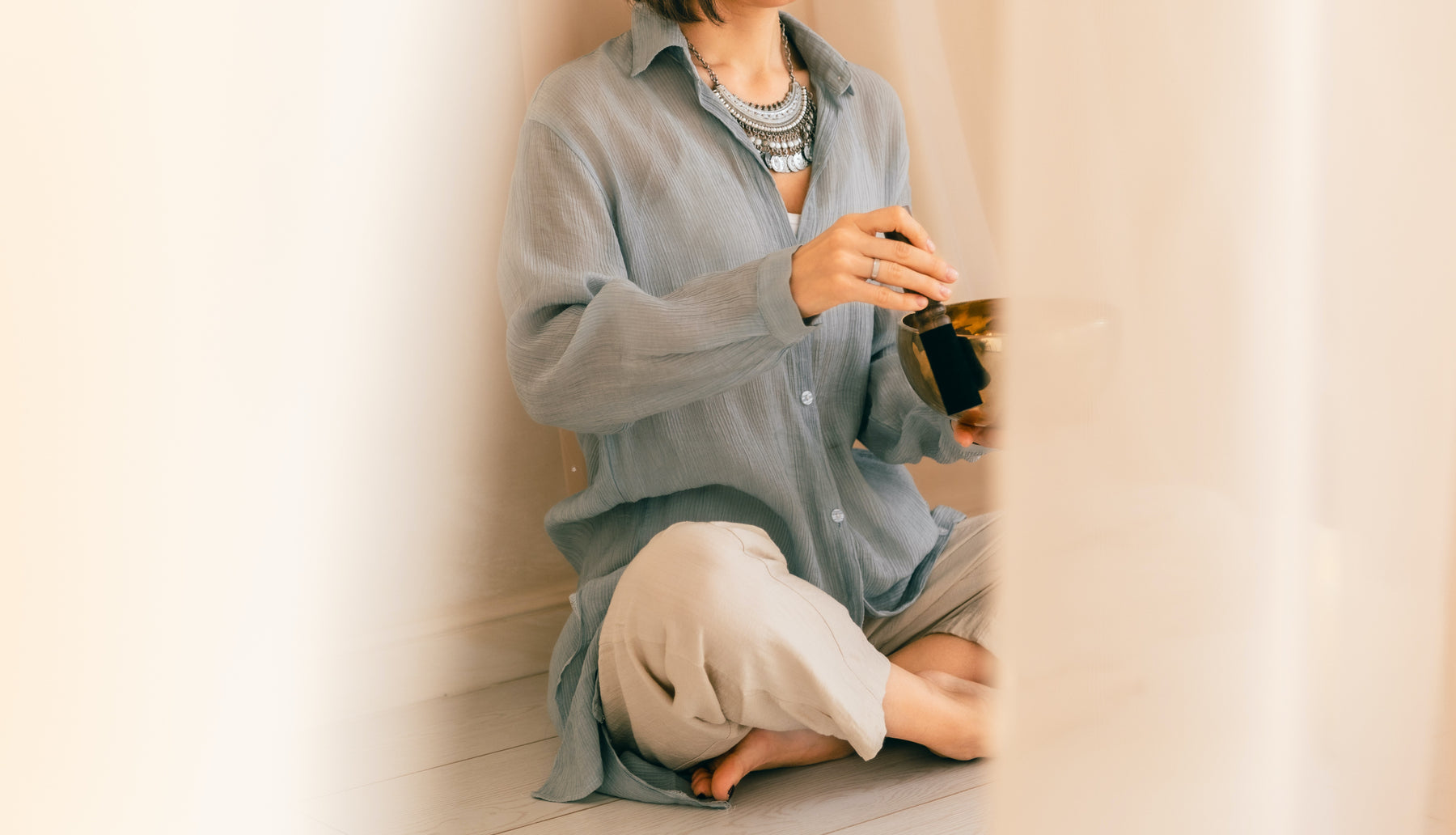 Woman in a serene home setting with a Serene Streams Tibetan singing bowl, handcrafted in Kathmandu Nepal